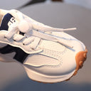 A boy in breathable white sneakers for children